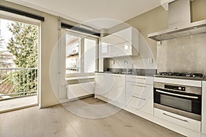 a kitchen with white cabinets and a large window