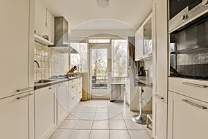 a kitchen with white cabinets and a large window