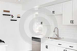 A kitchen with white cabinets and subway tile.