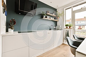 a kitchen with white cabinets and a tv on a