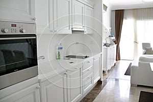 The kitchen is white with white cupboards, stove, refrigerator, sink. White room. Apartments.