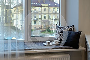 Kitchen wide windowsill with cups and pillows