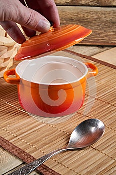Kitchenware. Colored ceramic saucepan on wooden background