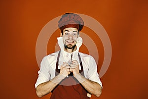 Kitchenware and cooking concept. Chef with excited face holds wooden spoon and spatula