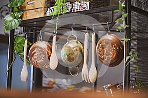 Kitchenware. A vintage photo of kitchen tools hanging in the kitchen including wooden ladle, wooden salad servers