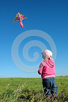 Kite against the sky. Girl keeps rope.