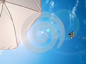 Kite background. Colorful high flying toy. Air kite fly on blue wind sky. Rainbow kite in summer clouds. Festive