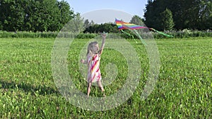 Kite launching. Little cute girl launches a kite in the meadow. Summer fun ideas for kids on vacation at summer camp. Ð¡hildren`s
