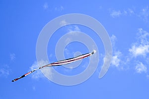 Kite long tailfly on blue sky. The colorful kite on the blue sky with clouds. Space for text