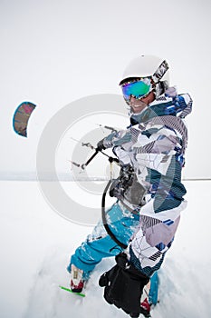 Kite surfer being pulled by his kite across the snow