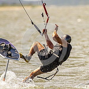 a kite surfer losing balance and falling off his board