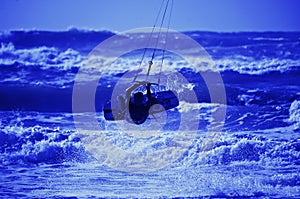 Kite surfer silhouette on blue sky background