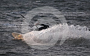 Kite surfer spraying water making a move