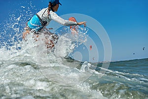 Kite surfer woman jumps with kite board