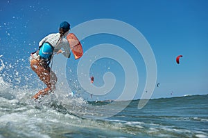Kite surfer woman jumps with kiteboard