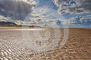 Kite surfers on broad sand rippled beach at Old Hunstanton, Norfolk, England