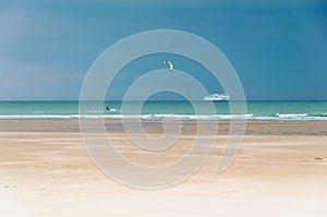 Kiteboarder on the sea in front of a ferry,