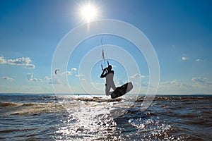 Kiteboarder surfing waves with kiteboard on a sunny summer day