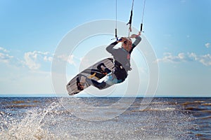 Kiteboarder surfing waves with kiteboard on a sunny summer day