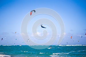 Kiteboarding. Fun in the ocean. Extreme Sport Kitesurfing. Kitesurfer jumping high in the air performing triks during