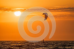 Kiteboarding kitesurfing kiteboarder kitesurfer kites silhouette in the ocean on sunset