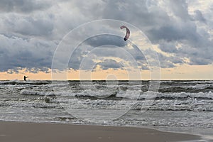 Kiteboarding. A man plays sports on the sea waves