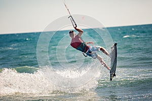 Kiter makes the difficult trick on a beautiful background. Kitesurfing Kiteboarding action photos man among waves