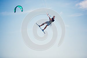 Kiter makes the difficult trick on a beautiful background. Kitesurfing Kiteboarding action photos man among waves