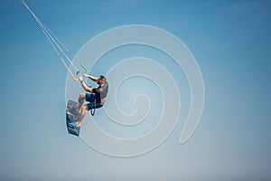 Kiter makes the difficult trick on a beautiful background. Kitesurfing Kiteboarding action photos man among waves