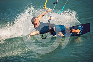 Kiter makes the difficult trick on a beautiful background. Kitesurfing Kiteboarding action photos man among waves