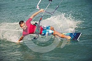 Kiter makes the difficult trick on a beautiful background. Kitesurfing Kiteboarding action photos man among waves