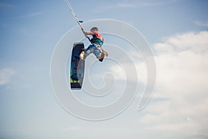 Kiter makes the difficult trick on a beautiful background. Kitesurfing Kiteboarding action photos man among waves