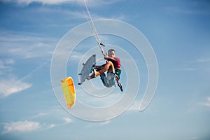 Kiter makes the difficult trick on a beautiful background. Kitesurfing Kiteboarding action photos man among waves