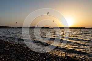 Kiters gliding over the Red sea surface. Extreme outdoor sport/activity/recreation. People in sport equipment riding on the water