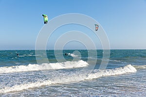 Kiters ride on the waves at Mui Ne beach,