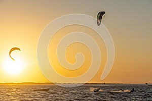 Kitesurf Kitesurfuer silhouette with yellowish background at sea