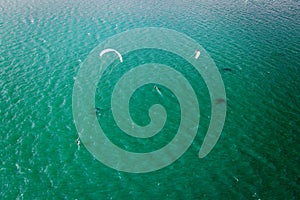 Kitesurfer in action on emerald water, aerial
