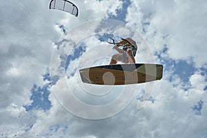 Kitesurfer in the cloudy sky with a kiteboard