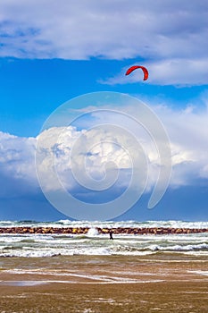 Kitesurfer riding on dangerous waves in winter storm