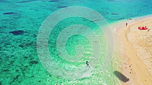 Kitesurfing Le Morne, Mauritius. Drone view flying backwards in front of kite surfer. Kite surfer surfing crystal clear water,