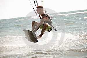 Kitesurfing. Man rides on kite on waves