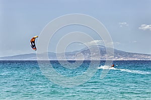Kitesurfing on the sea. Colorful kites fly in the blue sky.