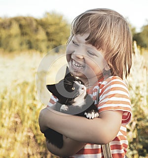 Kitten on the shoulder of the boy outdoors