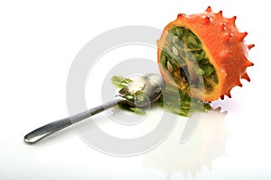 Kiwano and spoon on white background