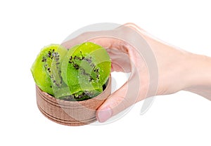 Kiwi candied fruit in wooden bowl in hand