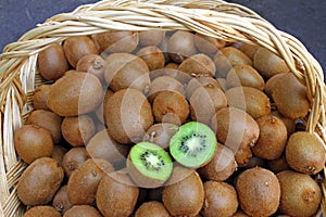 Kiwi. Fresh organic kiwis in knitted basket. Slice of colorful green kiwi fruit with seeds. Fruits background texture. Kiwi wallpa