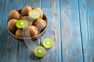 Kiwi fruit in bowl on blue wooden rustic table