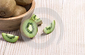 Kiwi fruit in a bowl on wooden