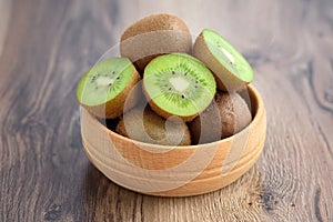 Kiwi fruit in a bowl on wooden background