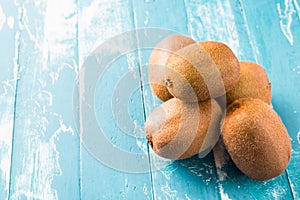 Kiwi fruit in a bowl on wooden background.